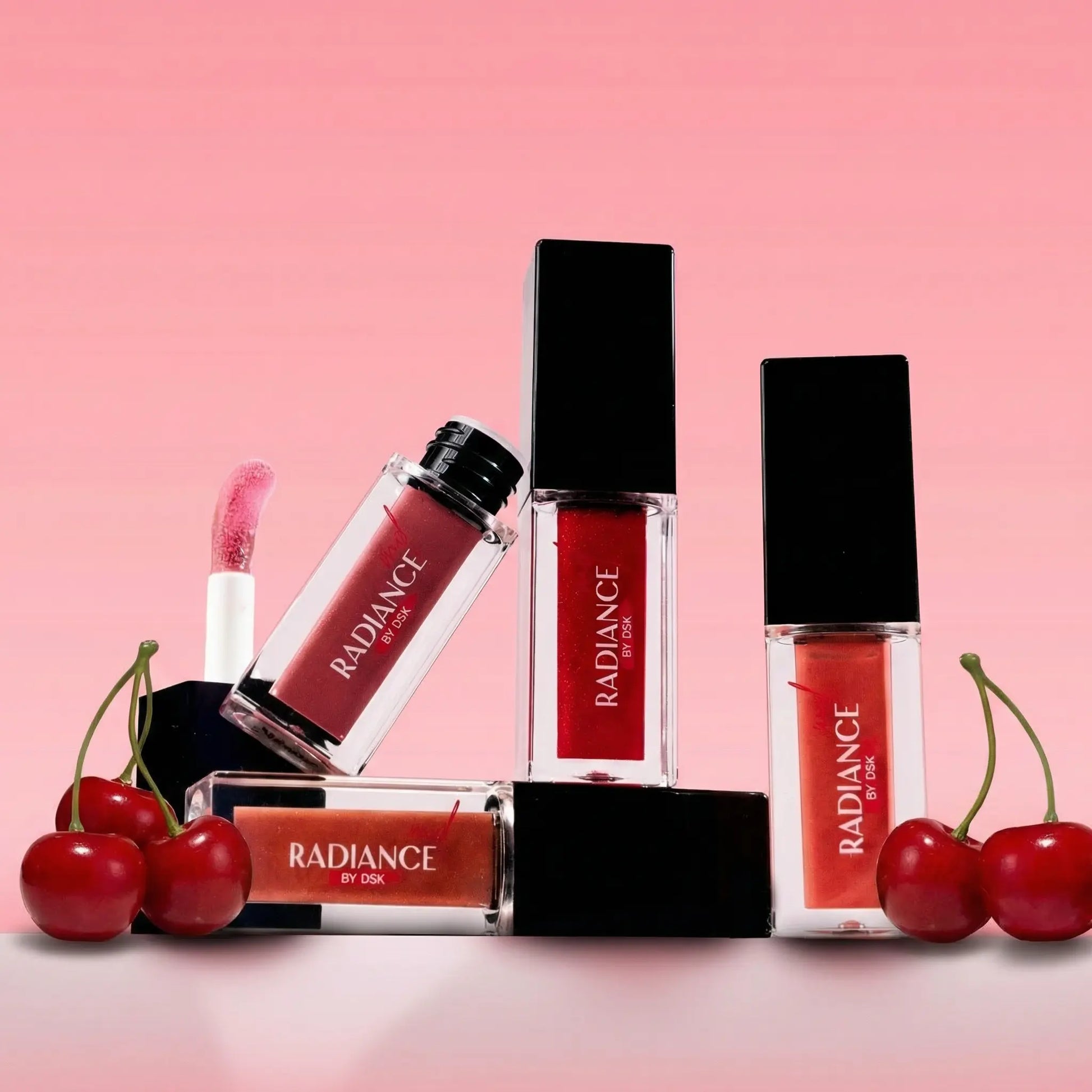 Radiance lip products with cherries on a pink background